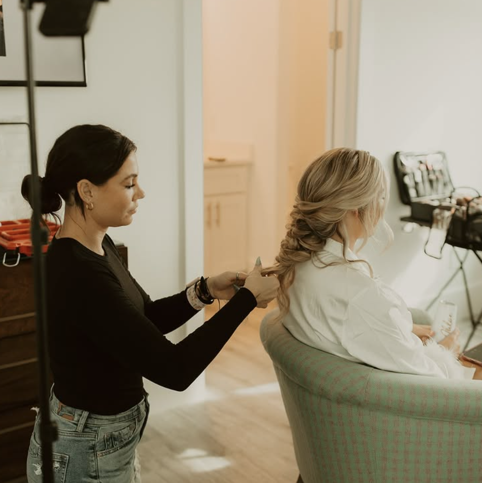 Stylist styling bride's updo from behind