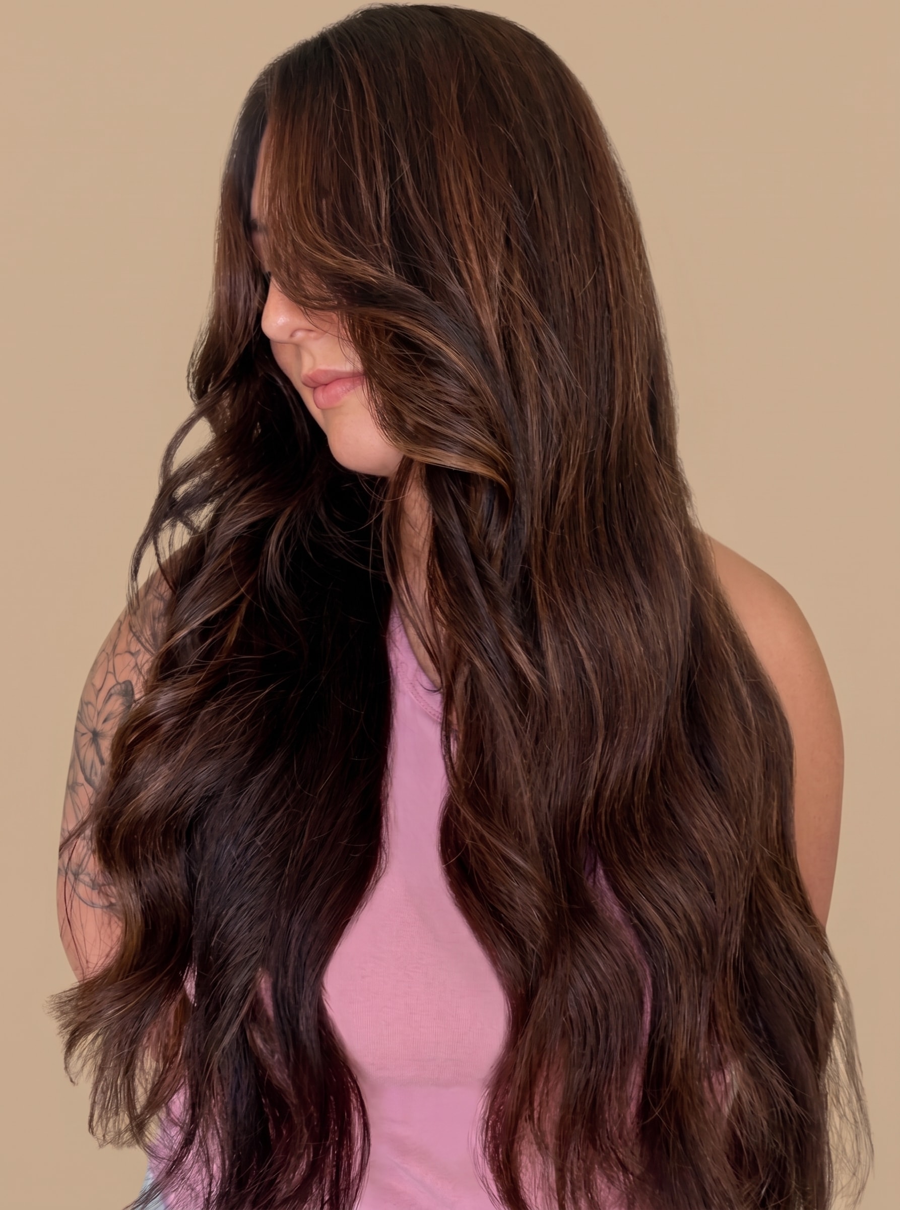Woman with long wavy dark brown hair with caramel highlights